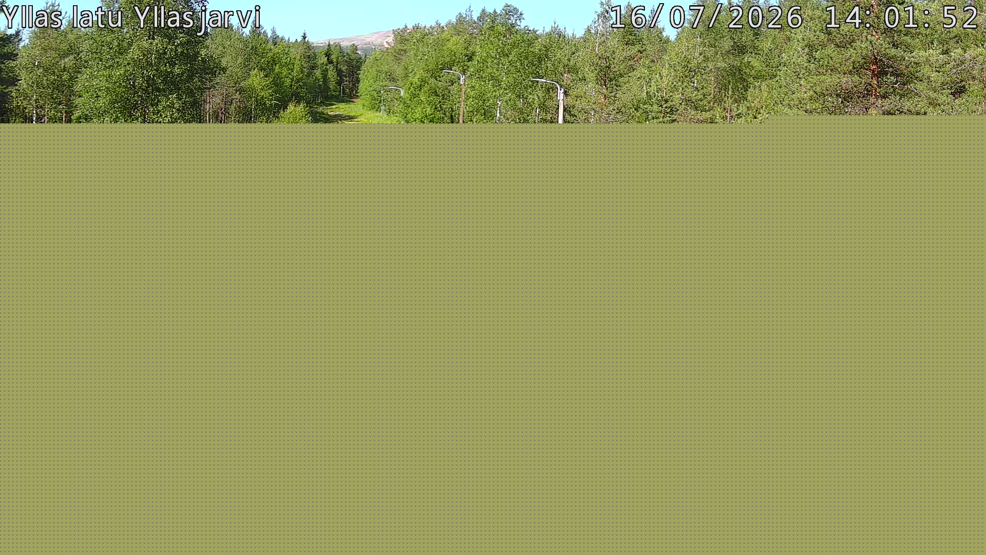 Talvella hieman mutkitteleva hiihtolatu, kesällä metsää, ja kauempana taustalla puiden yläpuolella hieman Yllästunturin rinnettä.